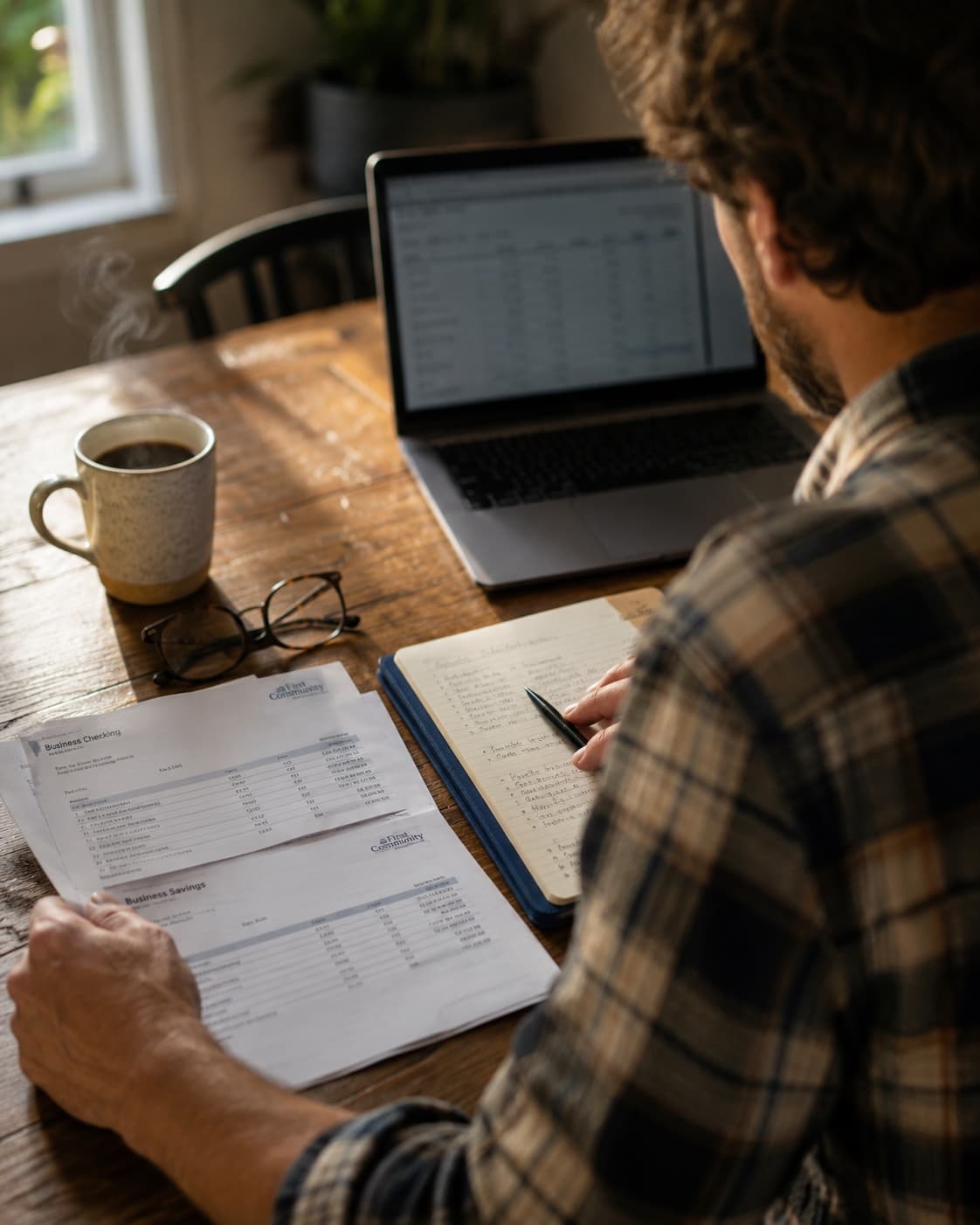 Business owner reviewing bank statements at their kitchen table